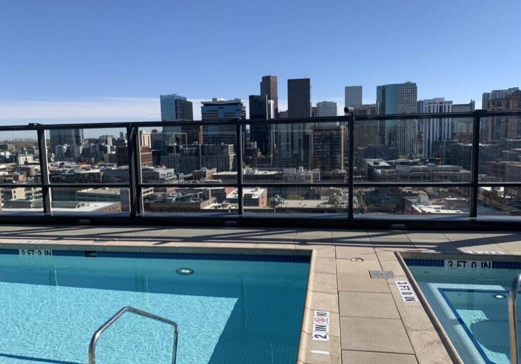 Rooftop pool with city skyline view.